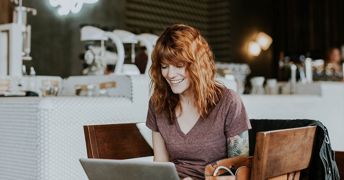 Happy woman typing on laptop