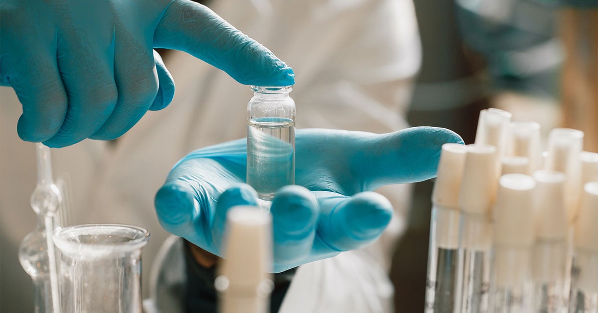 lab tech holding bottle of fluid